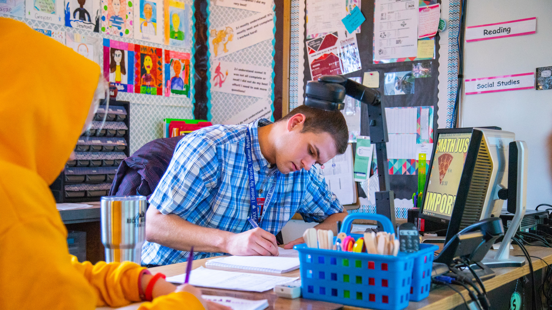 Male teaching working at desk at elementary school
